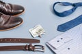 Men's clothes and accessories.tie and shoes shirt, belt money. on a blue background, copy space.Top view