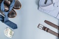 Men's clothes and accessories.tie and shoes shirt, belt money. on a blue background, copy space.Top view