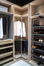 Men's clothes, shirts, pants shoes are kept in the modern convenient wardrobe, clean, organized wardrobe inside view