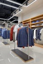 Men`s clothing store. Suits, shirts on shelves and hangers