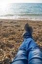 Men`s feet on the background of sea beach.