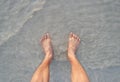 Men's feet on the beach. Royalty Free Stock Photo