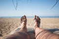 Men's feet on lounge in bungalow sea view Royalty Free Stock Photo