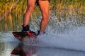 Men`s feet on a wakeboard in water.guy on the river and is preparing to go wake boarding Royalty Free Stock Photo