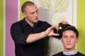 Men's hairstyling and haircutting with hair clipper and scissor