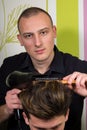 Men's hairstyling and haircutting with hair clipper and scissor