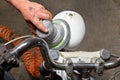 Men`s hand with a grinder polishing motorcycle headlight