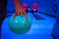 Men`s hand holding a blue bowling ball ready to throw