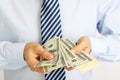 Men's hand holding money american hundred dollar bills. Hand of businessman offering money. Businessman counting money.