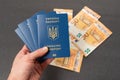 Men's hand holds four Ukrainian passports on cash euros background. Obtaining and exchanging foreign passport Royalty Free Stock Photo