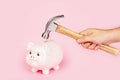 Men`s hand smashes with a hammer Piggy bank on pink background. mockup, template. Concept of financial crisis after coronavirus Royalty Free Stock Photo