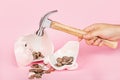 Men`s hand smashes with a hammer Piggy bank on pink background. mockup, template. Concept of financial crisis after coronavirus Royalty Free Stock Photo