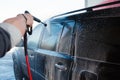 Men's hand wash dirty SUV by high pressure wash. Touchless car wash self-service in the open air. Contactless car wash self-servi Royalty Free Stock Photo