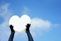 Men`s hands with a big heart made of snow, on blue sky background. Declarations of love, valentines, international womens or good Royalty Free Stock Photo