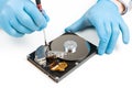 Men`s hands in blue gloves repairing dismantled hard drive. Computer maintenance, technology concept Royalty Free Stock Photo