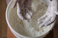 Men\'s hands brushed with white flour plastic bucket with wheat flour in the background
