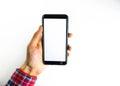 Men`s hands in a checkered hipster shirt are holding a smartphone on a white background. The screen is white and black. Hands Royalty Free Stock Photo