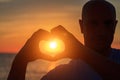 Men`s hands in the form of heart against sunlight in sunset sky, twilight time. Hands in shape of love heart, Love concept Royalty Free Stock Photo