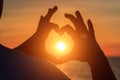 Men`s hands in the form of heart against sunlight in sunset sky, twilight time. Hands in shape of love heart, Love concept Royalty Free Stock Photo