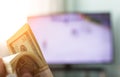 Men`s hands hold a bundle of money dollars against the background of a TV on which they show hockey, close-ups Royalty Free Stock Photo