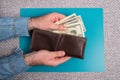 Men`s hands hold a leather wallet with dollar bills. Royalty Free Stock Photo