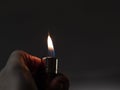 Men`s hands hold lighters, fire from cigarette. Burning lighter in a man`s hand. Blue flame of a lighter. The texture of the ski Royalty Free Stock Photo