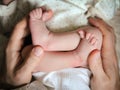 Men`s hands holding newborn baby feet