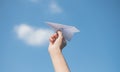 Men`s hands holding a white paper rocket with a bright blue background Royalty Free Stock Photo