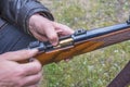 Men`s hands loading the hunting carbine with bullet