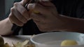 Men's hands peel potatoes at the kitchen table. A cinematic picture. The passage is from right to left