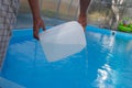 Men`s hands pour light liquid from a plastic tank into a pool, into water. chemical water purification, alkali balance, unsanitar