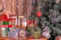 Men's hands pouring champagne from a bottle into champagne flutts against the background of a New Year tree and presents Royalty Free Stock Photo