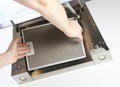 Men`s hands remove the grease filter from the kitchen hood.Remove the filters from the hood.