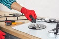 Men& x27;s hands repair the hob with a tool. The technician adjusts the burner of a gas stove. Royalty Free Stock Photo