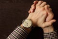 Men`s hands with retro wristwatch at the table. Meeting and deadline concept. Clasped hands. Elegant businessman hand top view.