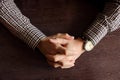 Men`s hands with retro wristwatch at the table. Meeting and deadline concept. Clasped hands. Elegant businessman hand top view.