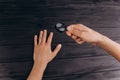 Men`s hands on a rustic black desk holding a magnifying glass. fingerprint examination. palm closeup Royalty Free Stock Photo