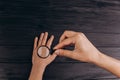 Men`s hands on a rustic black desk holding a magnifying glass. fingerprint examination. palm closeup Royalty Free Stock Photo