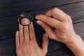 Men`s hands on a rustic black desk holding a magnifying glass. fingerprint examination. palm closeup Royalty Free Stock Photo