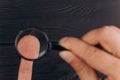 Men`s hands on a rustic black desk holding a magnifying glass. fingerprint examination. palm closeup Royalty Free Stock Photo