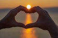 Men`s hands in the shape of a heart on a background of the sky at sunset. Love concept. Heart-shape hand gesture Royalty Free Stock Photo