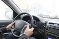 Men`s hands on the steering wheel of a car. The driver controls the car. View through the windshield.