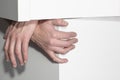 Men`s hands stick out of objects of furniture fittings