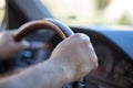 Men`s hands on the wheel of the car