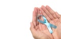 Men`s healthcare concept - close up of male hands holding light blue ribbon for prostate cancer isolated on white background Royalty Free Stock Photo