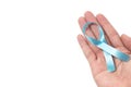 Men`s healthcare concept - close up of male hands holding light blue ribbon for prostate cancer isolated on white background Royalty Free Stock Photo