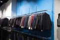 Men`s jackets or unisex hang in a row in a clothing store. Shop for children. Selling costumes, selling school clothes Royalty Free Stock Photo