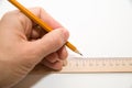 Men's left hand holding a pencil on over white