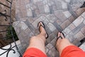 Men`s legs in black flip flops and red shorts go down and walk down the stairs. Walking style Royalty Free Stock Photo