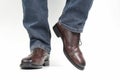 Men`s legs in jeans shod in classic brown Oxford shoes